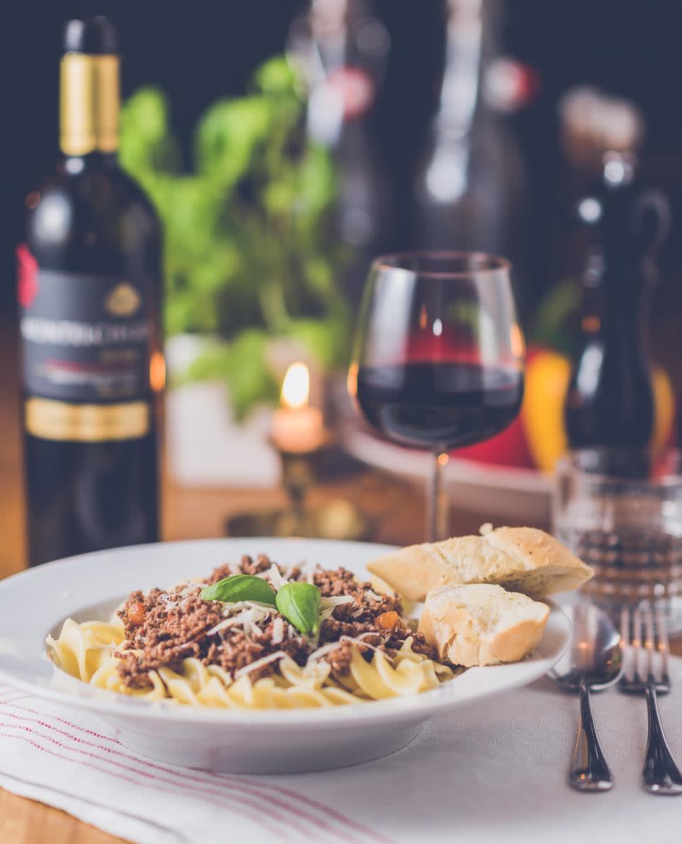 Piatto di pasta e calice di vino rosso